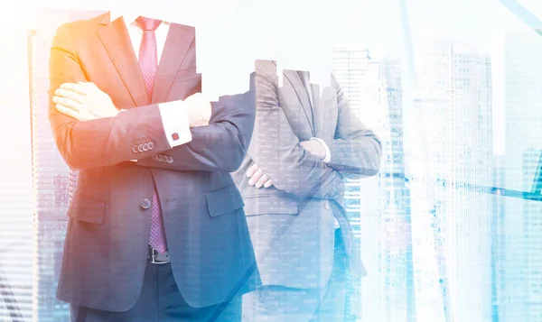 Zwei Geschäftsleute mit verschränkten Armen im Büro, Wolkenkratzern und Sonne — Stockfoto