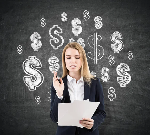 Woman signing contracts near dollar signs on blackboard — Stock Photo, Image