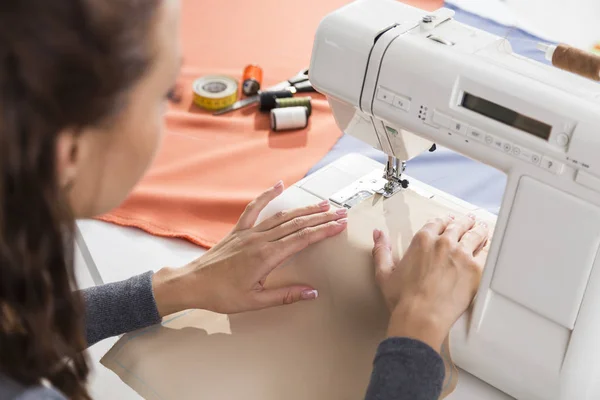 Närbild på vacker kvinnas händer använder en symaskin — Stockfoto