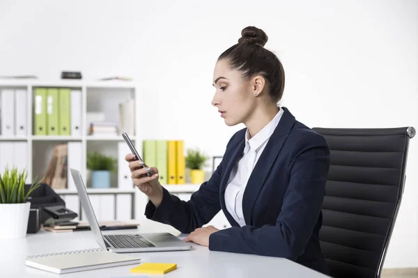 Mujer de negocios seria está mirando la pantalla de su teléfono celular —  Fotos de Stock