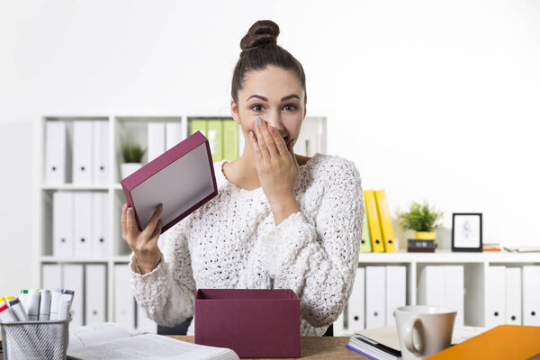 Женщина удивлена, увидев ее подарок и закрывает рот
