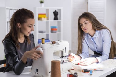 Siyah dikiş kızıdır. Onun iş arkadaşı notlar yapıyor