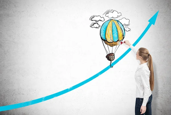 Woman drawing a graph and a hot air balloon — Stock Photo, Image