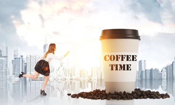 Girl running to a giant paper cup of coffee