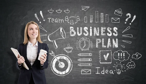 Blonde Frau mit einem Notizbuch und einer Tasse Kaffee und einem Business-p — Stockfoto