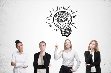 Dört kadın beyin fırtınası. Beton duvar. Ampul