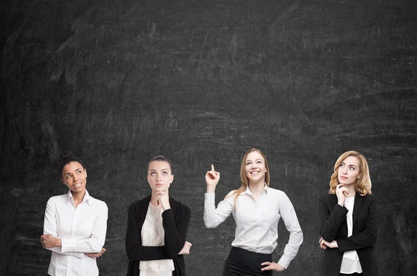 Four women brainstorm near blackboard — Stock Photo, Image