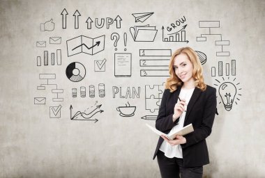 Kızıl saçlı işkadını beton duvar ile yakın bir defter ile 