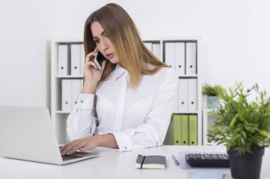 Telefonunu ofisinde sarışın kadın yanıyor