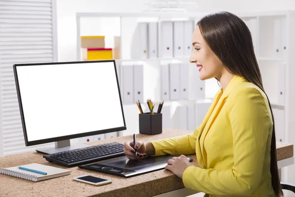 Γυναίκα σε ένα κίτρινο σακάκι σχεδίασης σε υπολογιστή της — Φωτογραφία Αρχείου
