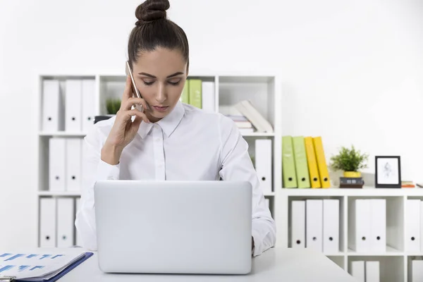 Wanita dalam blus putih pada ponselnya di kantor — Stok Foto