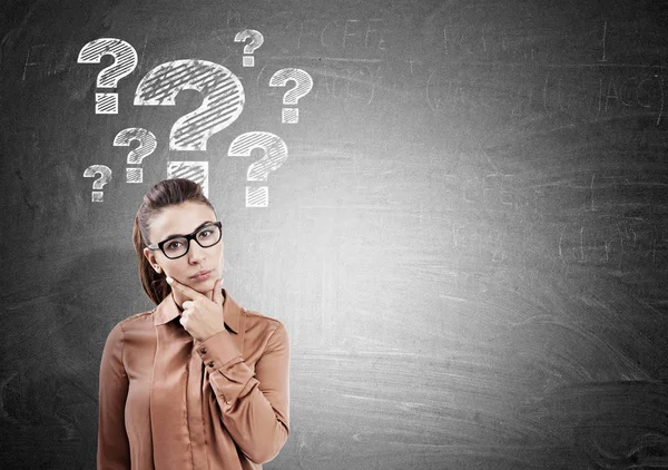 Thinking woman and question marks on chalkboard — Stock Photo, Image