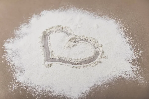 Heart in flour on beige table — Stock Photo, Image