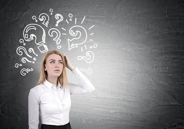 Blonde vrouw en vraagtekens op schoolbord — Stockfoto