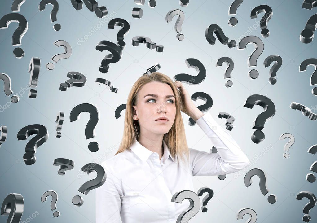 Blond woman and question marks on gray wall