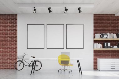 Sarı sandalye ve üç afiş ile ev ofis