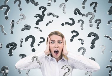 Şok kadın ve soru işaretleri, gri duvar