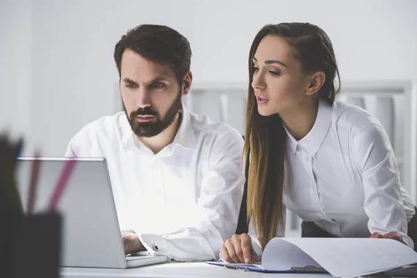 Homem digitando, mulher apontando para o documento — Fotografia de Stock