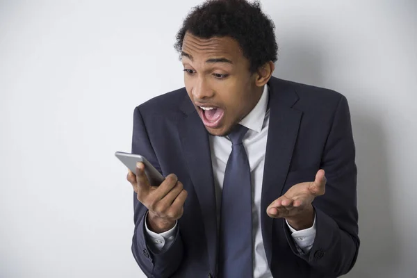 Förvånad African American man med en telefon — Stockfoto