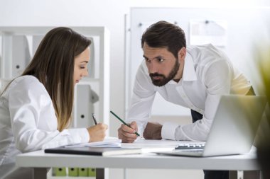 Adam onun iş arkadaşına bakarak ve yazarak
