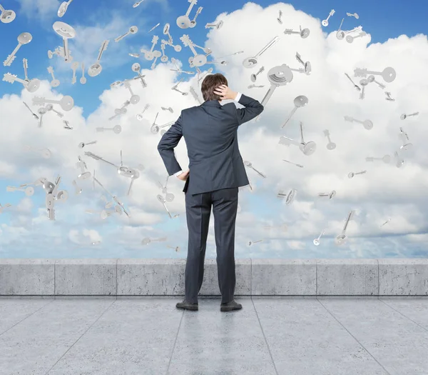 Rear view of man at a rooftop, keys fall — Stock Photo, Image