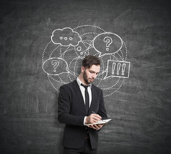 Hombre con cuaderno y bosquejo de preguntas y respuestas — Foto de Stock