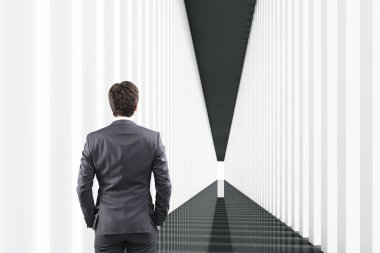 Siyah ve beyaz koridorda bir adam arkadan görünüş