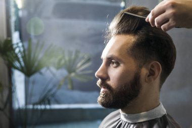 Konsantre kahverengi saçlı işadamı bir kuaför dükkanı taranmış saçları olan yakın çekim. 
