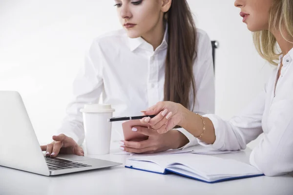 Närbild av två kvinnliga företagare vid ett bord i office. En är att skriva. Andra pekar med hennes penna. — Stockfoto