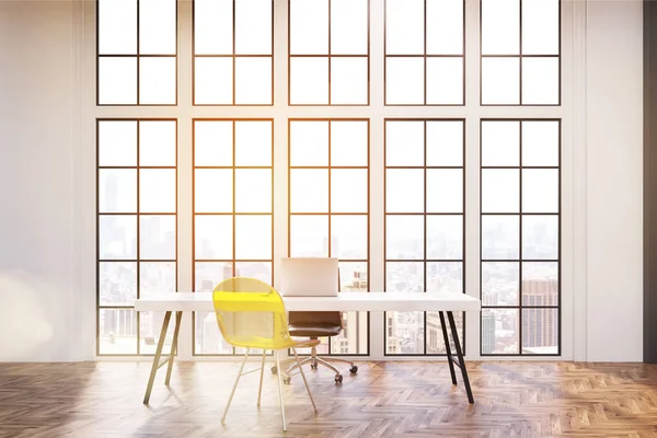 Arbetsplats med vita skrivbord, en kontorsstol och en transparent gul besökare stol. Stora fönster är i bakgrunden. — Stockfoto