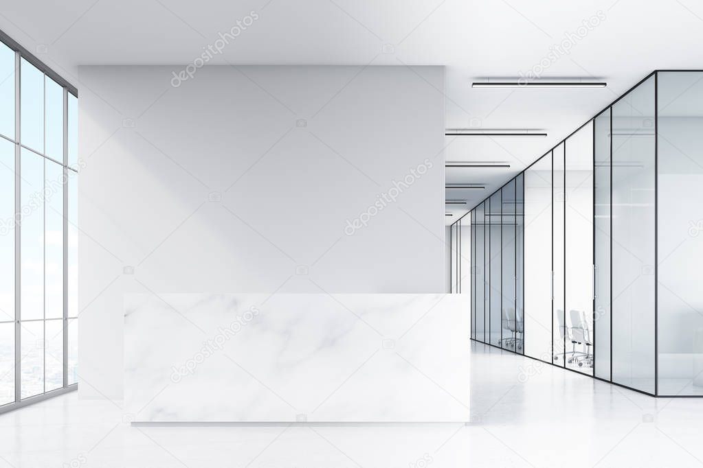 Office hall with panoramic windows and glass walls of meeting rooms. There is a marble reception counter in the left part.