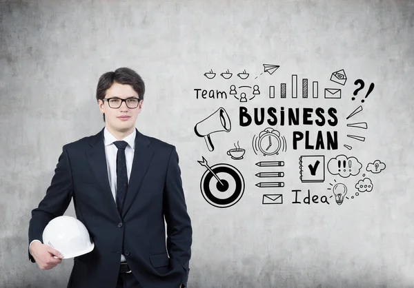 Man in hardhat and glasses, business plan