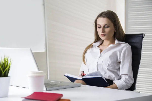 Affärskvinna med anteckningsboken i office — Stockfoto