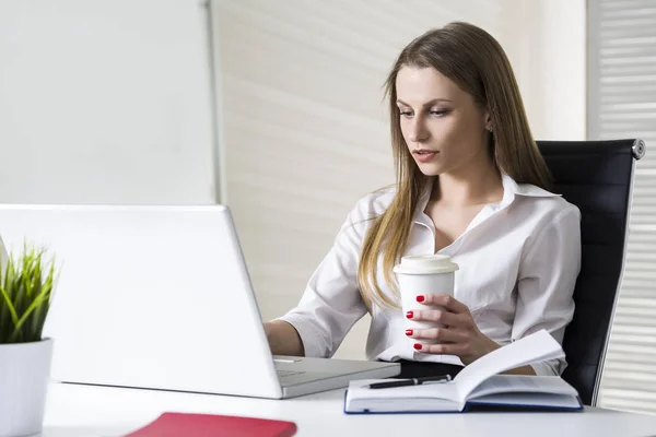 Zakenvrouw met een koffiekopje op kantoor — Stockfoto