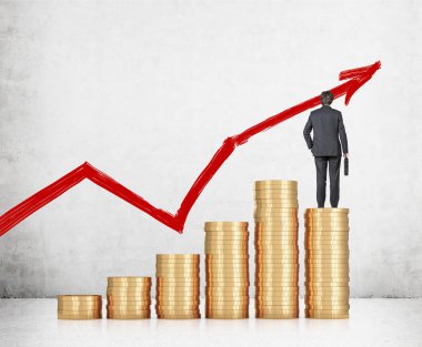 Para yığınının üzerinde duran bir işadamı.