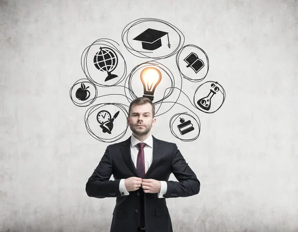 Man in suit and education icons on concrete — Stock Photo, Image