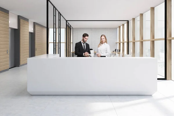 Люди на белой стойке регистрации в стеклянном офисе — стоковое фото