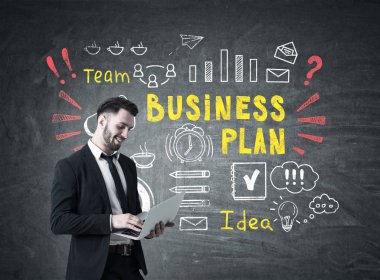 Dizüstü bilgisayar ve renkli iş planı olan adam