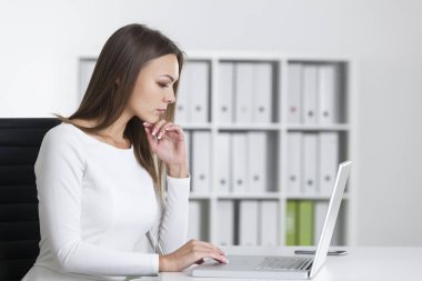 Dizüstü ciddi bir kadına yan görünüm 