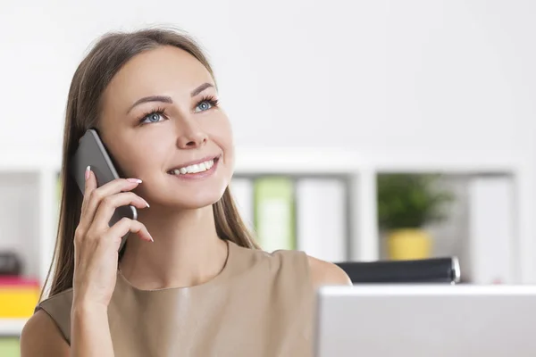 Close up of dreamy girl in beige on phone — Stock Photo, Image