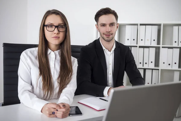 Ernste Frau und fröhlicher Mann im Amt — Stockfoto