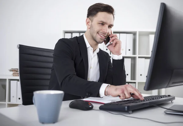 Smiling businessman with a smartphone typing — Stock Photo, Image