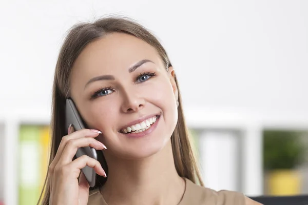 Primer plano de chica alegre en beige en el teléfono — Foto de Stock