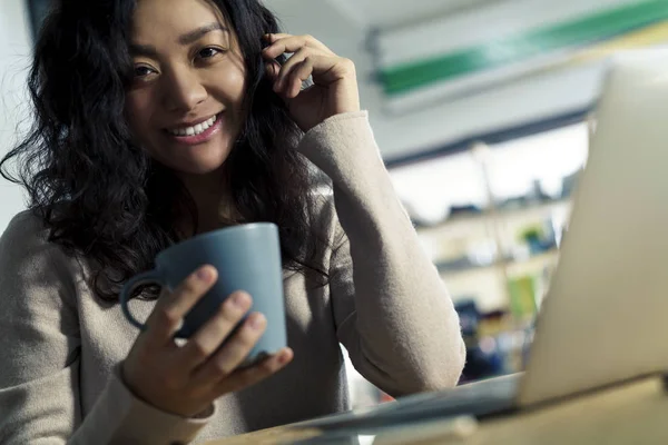 Asiatisk tjej med telefon tittar på dig — Stockfoto