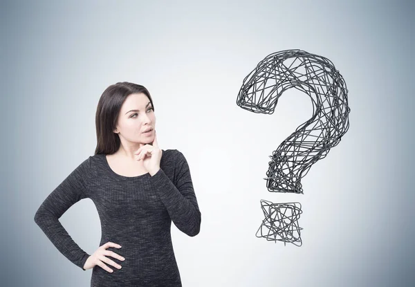Woman in dress and question mark on gray wall — Stock Photo, Image