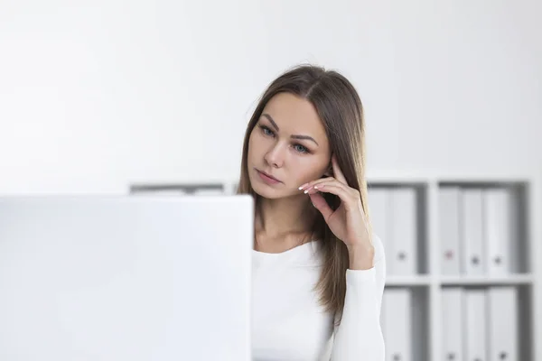 Sad woman in white office looking at screen — Stock Photo, Image
