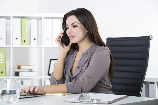 Empresária em cinza em seu telefone, digitando — Fotografia de Stock