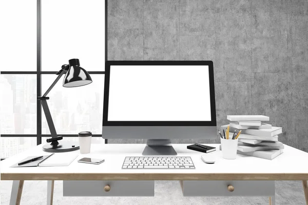 Computer screen, concrete wall, books — Stock Photo, Image