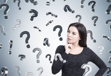 Kadın elbisesi ve gri duvar üzerinde soru işaretleri