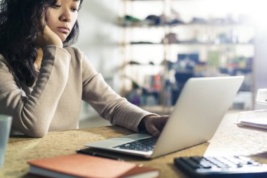 Laptop yazarak sıkılmış Asyalı kadın 